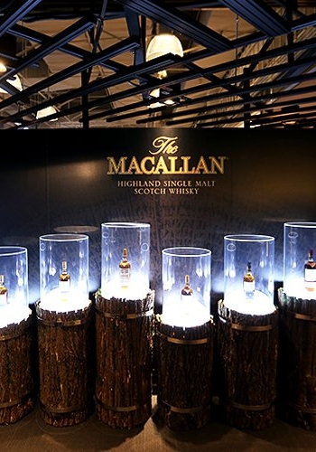 Macallan Whiskey Experience Exhibition Design by Studio Königshausen. Toast the Macallan is a versatile venue, housing a pop-up event, retail store, and evening bar. By day, it welcomes walk-in customers to a dynamic shopping and exhibition area. The space transforms into an intimate bar as night falls, offering exclusive tasting sessions.